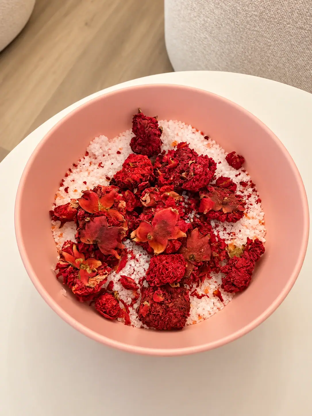 Rosa Schale mit Badesalz und getrockneten Rosenblüten für das Foot-Spa